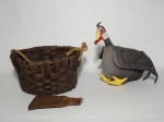 Dois itens, sendo 1 cesto e 1 escultura feita de tecido, representando uma galinha d´Angola. O cesto mede 28 cm de diâmetro x 15 cm de altura. Galinha 30 cm x 25 cm.
