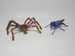 Dois itens representando animais, sendo 1 aranha feita de chapinhas de metal e 1 gafanhoto de origem chilena, assinado Patricia Ramiry Lopez. A aranha  26 cm de diâmetro e o gafanhoto  17 cm de comprimento.