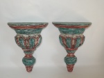 HUMBERTO ARAUJO - Par de peanhas em madeira, patinadas de verde e vermelho, com parte inferior no formato de gomos. Não apresenta assinatura. Mede a base 25 cm de comprimento x 13 cm de profundidade x 34 cm de altura.