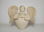 Escultura de terra-cota representando um anjo lendo. Mede 28 cm de altura.