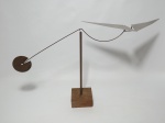 Escultura em metal representando uma asa delta em base de madeira, inspirada em obra de Alexander Calder. Medindo a base 9 cm x 9 cm, 64 cm de largura e 33 cm de altura.