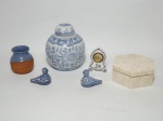 Lote comporto de 6 itens de materiais, modelos e procedências diversos, sendo: 1 potiche de porcelana oriental nos tons de azul e branco, medindo 16 cm de altura; 1 porta-joia revestido em osso no formato sextavado medindo 13 cm de diâmetro e 5 cm de altura; 2 pássaros em porcelana de origem chilena nos tons de azul e branco, 1 mini relógio com estrutura em porcelana decorada com flores, funcionamento a Quartz, 1 vaso nos tons de telha e azul, medindo 8 cm de altura.