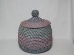 Grande balaio de palha revestido com tecido Patchwork, no formato redondo, tampa com pega no formato de bola. Mede 30 cm de diâmetro x 45 cm de altura, incluindo a tampa.