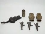 Sete itens em metal, sendo: 1 cabide no formato de gato; 3 adornos de cavalaria em metal prateado e 3 querubins em ferro. O cabide mede 16 cm de altura, os adornos 8 cm de comprimento e os querubins medem 7 cm de altura.