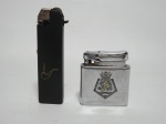 Dois isqueiro: Metal prateado decorado com brasão e outro negro, para cachimbo. Alts. 5 e 8cm.