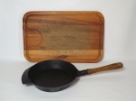 Dois itens para cozinha, 1 frigideira em ferro com cabo em madeira e 1 tábua para carne em madeira (com marcas de uso). A tábua mede 47 cm de comprimento x 30 cm de largura. A frigideira mede 24 cm de diâmetro x 50 cm de comprimento, incluindo o cabo (cabo está frouxo).