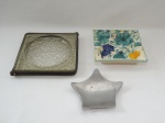 Três cinzeiros: 1 em metal no formato de estrelas; 1 em porcelana decorado com frutas e folhagem. Marcado Luiz Salvador - Itaipava e 1 em vidro canelado com detalhe em couro. Comps. 16 a 21cm.