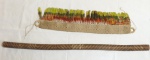 ARTE INDÍGENA - Duas peças: a) Pau de chuva, instrumento musical idiofônico, (o próprio corpo do instrumento que produz o som). palha recheada com sementes. Comp. 104cm. b) Tanga em palha e penas coloridas. Comp. 70cm.