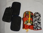 Cinco luvas pegadoras de pratos quentes, cores e modelos diversos (1 no formato de Matrioska). Sinais de uso.