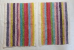 Dois tapetes para banheiro, felpudos, com listras multicoloridas. 70 x 54 cm. (Com marcas de uso).