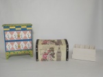 Três itens, 1 mini gaveteiro delicado, feito de madeira, composto de 2 gavetas, decorado com motivo de flores, medindo 19 x 9 x 23 cm; 1 baú revestido com tecido com motivos florais e foto do Big Ben Clock Tower, 12 x 16 x  22 cm, 1 porta controle remoto em MDF, patinado de branco, medindo 10 x 14 x 8 cm.