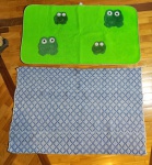 Dois tapetes para banheiro, sendo 1 verde com desenho de sapos, 130 cm x 70 cm, 1 em algodão rústico azul feito em tear, 130 cm x 87 cm.