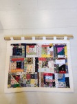Belíssimo painel feito artesanalmente, com uma variedade de tecidos e acessórios diversos, barra em brim cru, varão em bambu. Mede 100 cm x 60 cm.
