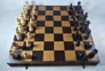 Antigo jogo de xadrez produzido em madeira, tabuleiro com dobradiça para o abrigo das peças e alternativa para viagem. Marcas de uso, time preto com um dos cavalos faltando a cabeça, no estado, tabuleiro aberto com 33 cm X 33 cm.