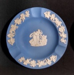 WEDGWOOD - Lindo cinzeiro em porcelana  Biscuit Inglesa , bordas decoradas com cachos de uva, e ao fundo figuras angelicais,  acondicionado na caixa original, contendo livreto com história do fabricante. Medida: 11cm de diâmetro.