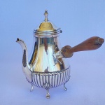 REBOUÇAS - Antigo bule de café em metal espessurado a prata com base canelada, quatro pés e cabo em madeira. Med.: 18cm de altura e 19cm de lagura. Tampa está solta.