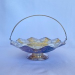 ART PRATA - Cesta redonda em metal espessurado a prata 90 decorada com recortes nas bordas com cinzelado de volutas e alça articulada. Med.: 8,5cm de altura e 23,5cm de diâmetro. Apresenta desgastes e perdas no banho.