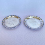 EBERLE - Par de descanso de copo em metal espessurado a prata com bordas onduladas e cinzeladas de folhas com fundo efeito martelado. Med.: 10cm de diâmetro.