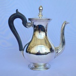 CRISTOFLE - Bule para café em metal banhado a prata com pegador em pinha e cabo de madeira. Med.: 24,5cm de altura e 24cm de largura. Apresenta pequena mossa e desgaste.
