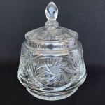 Bomboniere com tampa, em cristal europeu, ricamente lapidada com palmas e estrelas, pega na forma de pinha facetada. Med.: 23cm de altura