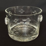 Antigo balde de gelo em cristal decorado com lapidações de folhas e linhas na baso e dois pegadores, med. 9,5cm de altura e 13,5cm de diâmetro.