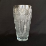 Vaso para flores em cristal europeu com lapidações de estrelas e geométricos, med. 25,5cm de altura e 14cm de diâmetro (borda). Apresenta bicado na borda