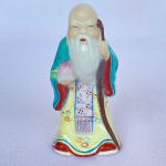 Escultura em porcelana policromada pintada à mão de sábio ou mestre chinês, numerada na base. med. 10cm de altura