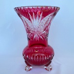 Vaso em cristal doublé na cor rosa e translúcido com decorações em formatos geométricos, folhas e flores, com bordas recortadas. Med.: 25cm de altura e 17,5cm de diâmetro. Apresenta bicados nos pés e borda, e restauro na borda.