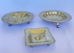 Lote com 3 (três) salvas em metal espessurado a prata boliviano com efeito martelado com pés, duas quadradas e uma redonda. Med.: Maior com 20cm de diâmetro e 5cm de altura.