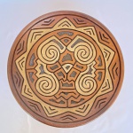 OLGA PARÁ - Prato decorativo de pendurar em barro cozido com decorações em auto relevo em espirais e formatos geométricos. Assinado. Med.: 29cm de diâmetro.