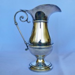 EBERLE - Jarra bojuda com aparador de gelo em metal espessurado à prata com pegador em voluta. Med.: 26cm de altura e 19cm de largura.
