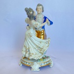 VIEIRA DE CASTRO RIO - Estatueta de casal em cena de valsa em porcelana branca com decorações de flores na base. Med.: 24,5cm de altura e 14cm de largura. Apresenta restauro.