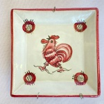 Pequeno prato de parede italiano em porcelana branca com desenho de galo na cor vermelha. Med.: 10x10cm.