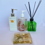 Lote com 4 (quatro) peças para banheiro sendo: Uma saboneteira e um dispenser de sabonete líquido em acrílico com parte interna de conchas; Um difusor da Perfumaria Phebo de vidro na cor verde (vazio)  e um dispenser para sabonete líquido de cerâmica na cor branca com desenhos de flores laranjas. Maior medindo: 19cm de altura.