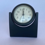 QUARTZ - Antigo relógio de mesa com alarme feito com plástico na cor preta. Med.: 13cm de altura. Funciona a 1 pilha AA. Não testado.