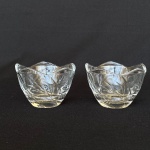 Par de castilal de vidro com borda recortada e decoração de autorelevo de folhas. Med.: 6cm de altura e 8,5cm de diâmetro.