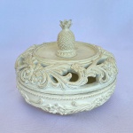 ZARA HOME - Caixa porta-jóia feito em resina na cor branca com tampa vazada e decorada com arabescos e flores com pega em abacaxi. Med.: 11cm de altura e 13,5cm de diâmetro.