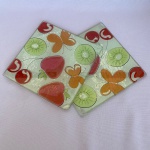 Par de descanso de penela quadrado de vidro com fundo de frutas e borboletas. Med.: 18cm. Um com bicado.