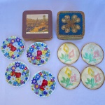 Lote com 20 (vinte) porta copos sendo, quatro de madrepérola com borda em metal dourado e fundo em cortiça com 8cm de diâmetro; quatro de porcelana branca com pintura de flores e 9cm de diâmetro (um está quebrado e colado); seis de madeira com cortiça na cor marrom com paisagens de Edimburgo com 10x10cm; e seis de madeira com decorações em arabescos e fundo dourado medindo 9x9cm.