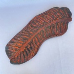 Antiga bandeja em madeira pintada na cor preta no formato de folha patinada em vermelho, med. 41X15cm