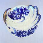 ZAPPI S/A - Fruteira em porcelana decorada com flores, volutas em relevo, em tons de azul e dourado, med. 24cm de diâmetro. Apresenta desgaste no dourado e bicado na borda