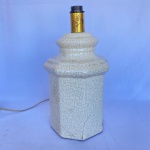 Base para abajur em porcelana na cor branca craquelada. Med.: 36cm de altura e 20cm de largura. Possui parte quebrada e apresenta restauros. Funcionando, sem garantia.