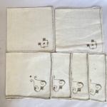 Conjunto com 6 (seis) guardanapos na cor creme com bordado, med. 40X40cm. Um com furo e apresenta mancha