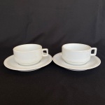 STEATITA - Par de xícaras com pires em porcelana, um com bicado em baixo. Med.: 5,5cm de altura e 10cm de largura; 17cm de diâmetro.