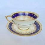PARAGON FINE BONE CHINA - Xícara e pires em delicada porcelana inglesa na cor branca com faixas azul cobalto e frisos dourados. Med.: 6x10cm (AxD); e 14cm de diâmetro. Marcação em baixo e algumas manchas do tempo.