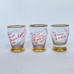Conj. com 3 (três) copinhos para coquitel em vidro com receitas escritas à mão, base e borda em dourado, med. 7cm. Pequenos bicados na borda