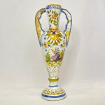 Antiga ânfora em porcelana francesa com pintura à mão de flores, arabescos e figura feminina da região de Perros-Guirec França. Med.: 25,5cm de altura. Possui restauros nas alças e bicado no bocal.