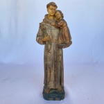 Estatueta em gesso de Santo Antonio de Pádua segurando criança sobre a bíblia, med. 31,5cm de altura.