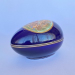 Antigo ovo em porcelana na cor azul cobalto com cenas, frisos e borda dourados, med. 10X10X15cm - Tampa apresenta restauro.