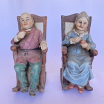Par de estatuetas em bisquit de casal de idosos sentados de cadeiras de balanço, med. 17X8X10cm (A.C.L.)